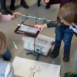 Kinder schauen auf ein Experiment mit einem Tablet