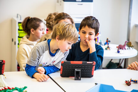 Zwei Jungen im Grundschulalter schauen gemeinsam auf ein Tablet