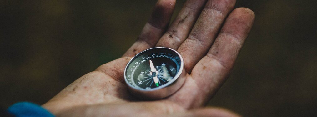 Ein Kompass liegt auf einer Hand.