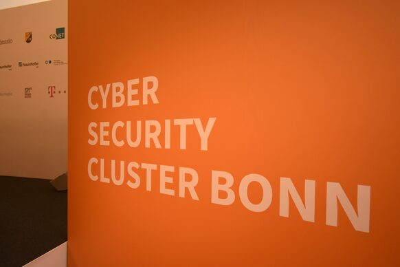 Ein orangefarbenes Schild mit der Aufschrift Cyber Security Cluster