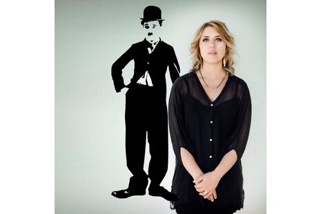 Foto der Künstlerin Gabriela Montero mit einem Hintergrundbild von Charlie Chaplin