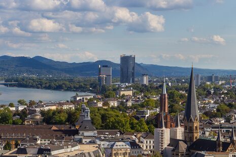 Blick vom Stadthausdach auf die Bonner Innenstadt. Im Hintergrund sind Posttower, UN-Tower und Siebengebirge.