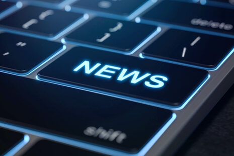Sulla tastiera nera di un computer portatile c'è un campo di immissione con la scritta News.
