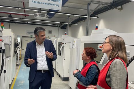 Ο Ümit Aydin από την GKN συνομιλεί με τη δήμαρχο Katja Dörner και την υπεύθυνη προώθησης επιχειρήσεων Victoria Appelbe, στο βάθος μηχανήματα.