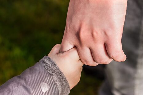 La main d'un enfant saisit l'index d'un adulte