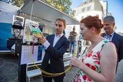 Kevin Horak vom Gighabit-Büro des Bundes erklärt OB Katja Dörner einen Gebäudeverteiler.