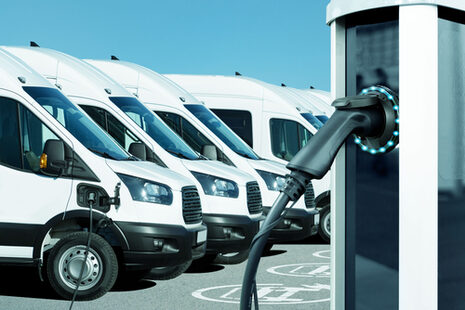 Białe samochody dostawcze z napędem elektrycznym podczas ładowania
