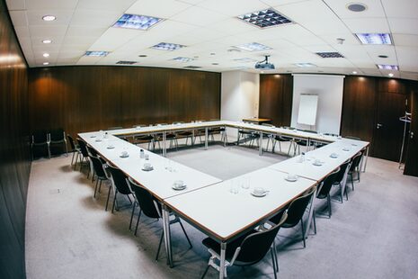 Una sala riunioni nel municipio con sedie e tavoli.