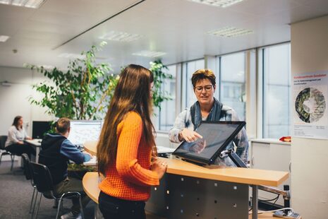 Un empleado atiende a un cliente en el centro de atención al cliente de geodatos.